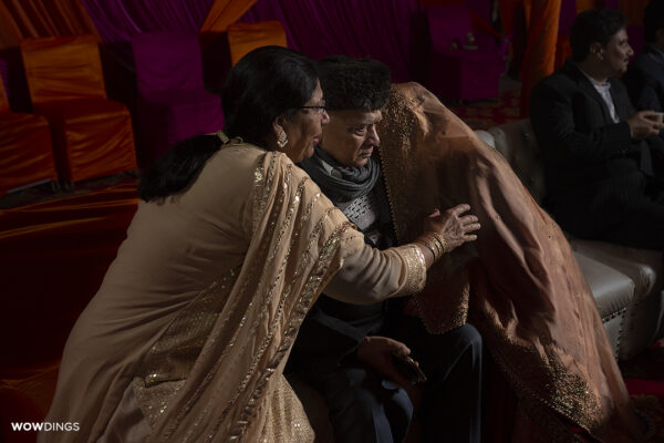Bride crying at vidaai rukhsati while parents comfort her at a muslim wedding in delhi