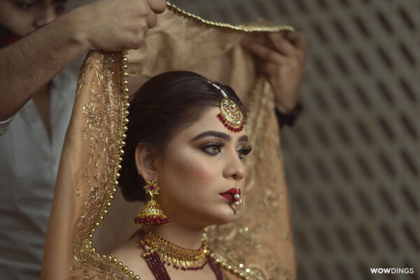 Gorgeous Bride putting on Veil at a muslim wedding in delhi in makeup artist studio