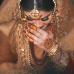 Beatiful shy muslim bride coy smiling showing moroccan mehndi mandala pattern at a Muslim Wedding in Delhi