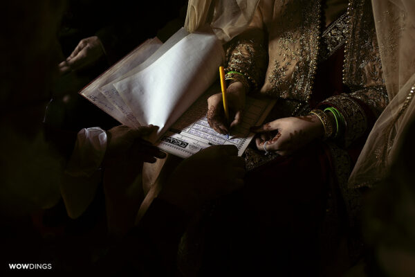 Beautiful muslim bride Signs the Nikaahnama marriage contract at a wedding in delhi