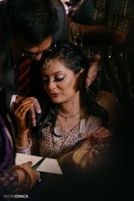 casual bridal moment during godh bharai ritual showering bride with gifts at an indian wedding in delhi on engagement day candid photography