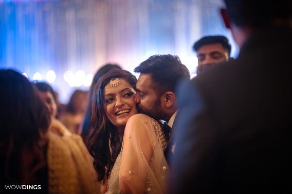 couple kissing casual moment at a delhi wedding sangeet ceremony candid photography