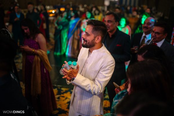 Audience applauding for people on stage sangeet ceremony dance night indian Superman got hitched candid wedding photography