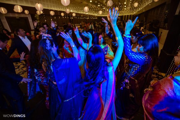 People Cheering on sangeet ceremony at an indian wedding in delhi on engagement day candid photography