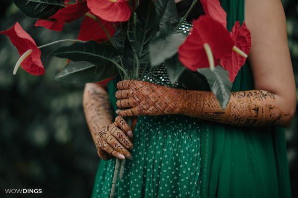 bridal portrait with red peace lily at Mehndi Ceremony of Delhi wedding candid photography