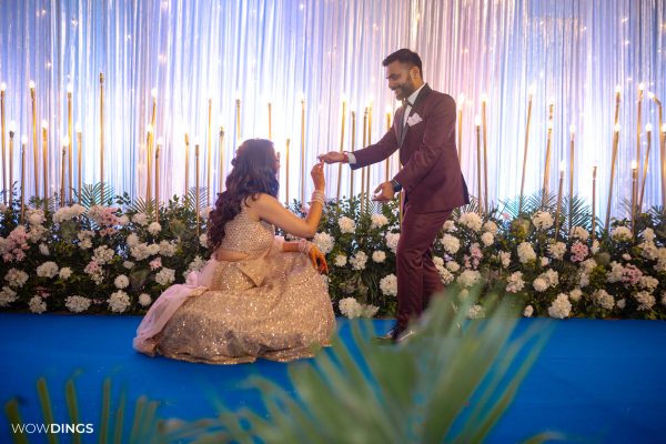 bride went down on her knees to propose groom on engagement ceremony in an indian wedding in delhi candid wedding photography