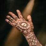 Muslim bride's hands with intricate mehndi designs during a vibrant ceremony