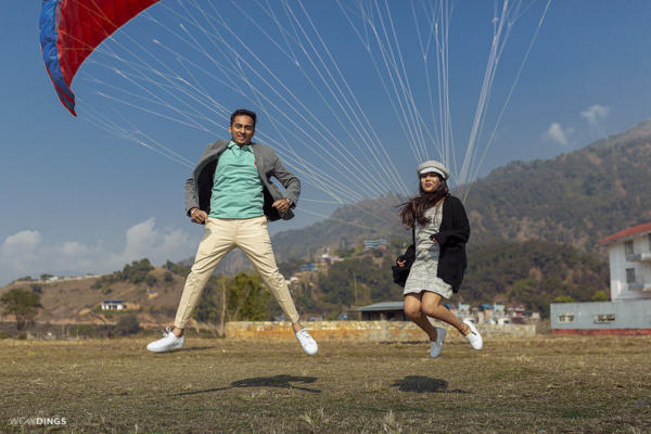 couple making fun at paragliding field