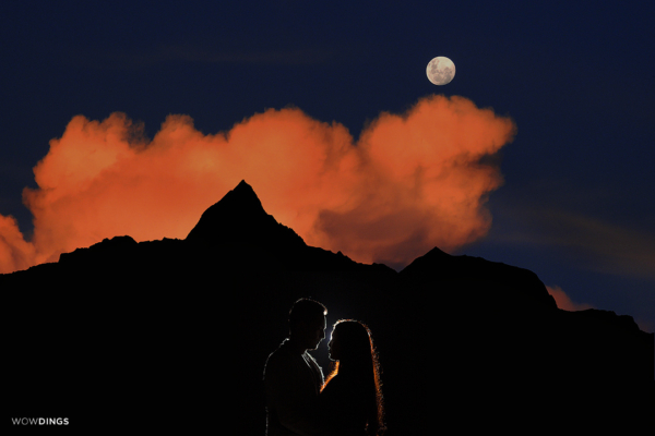night prewedding photography of couple with red cloud and moon