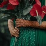 bridal portrait with red peace lily at Mehndi Ceremony of Delhi wedding candid photography